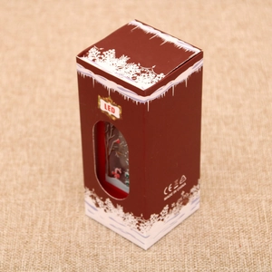 Close-up of a festive Christmas LED lantern packaging box with white snowflake patterns