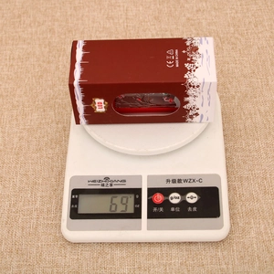 Detailed view of the Christmas LED lantern gift box being weighed on a scale at 69g