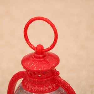 Close-up of a red Christmas lantern with gold glitter finish and circular hanging ring