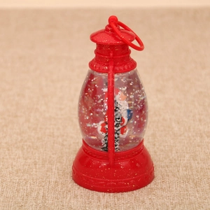 Close-up of red Christmas lantern snow globe with snowman and silver glitter flakes