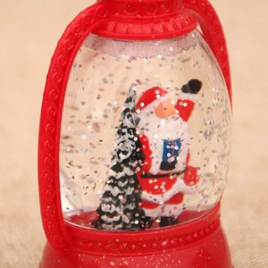 Detail of red Christmas lantern globe with Santa Claus, snow glitters, and liquid inside