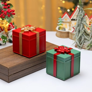 Detailed close-up of decorative Christmas gift box ornaments with golden ribbons and matte finish