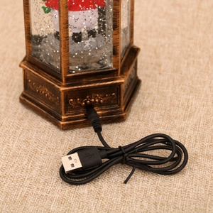 Close-up of USB charging port on vintage Christmas snow globe lantern base