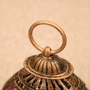 Close-up of vintage bronze lantern top with metal hanging ring and mosaic glass details