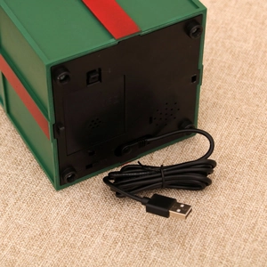Detail of green musical gift box base with battery compartment and USB power cable
