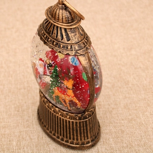 Close-up of vintage bronze Christmas lantern with Santa scene and swirling glitter water