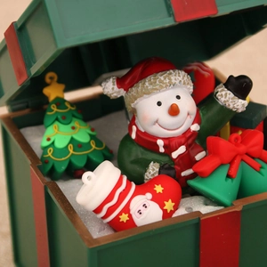 Macro detail of Christmas miniature set with snowman, tree and bells in a gift box