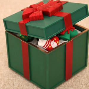 Close-up of a festive green Christmas gift box featuring a red bow and Santa doll