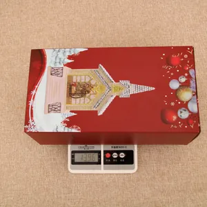 Detailed weight display of the festive red Christmas house gift box on a digital scale