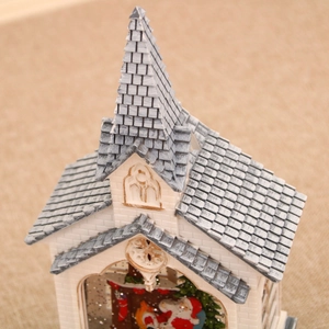 Macro detail of Christmas church music box showing Santa Claus inside the snow globe
