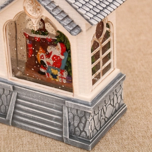 Detail of Santa inside a vintage house lantern with artificial snow and glitter
