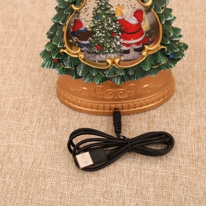 Detail of a musical glowing Christmas tree decor with USB cable and snow globe