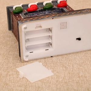 Close-up of the battery compartment and power switch on the Christmas fireplace music box