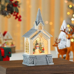 Close-up of white Christmas church lantern with snowman scene and warm LED light decoration