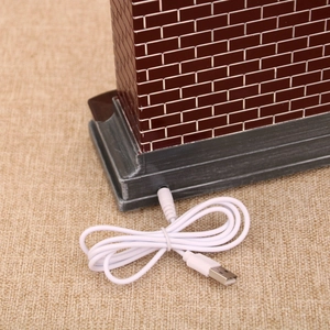 Detail of red brick wall Christmas music box base with white USB power cable connection