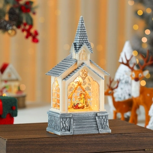 Macro view of light-up church snow globe with Nativity scene on vintage stone base