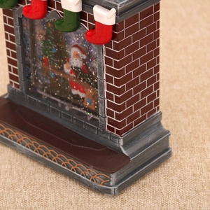 Macro detail of Christmas fireplace music box with Santa Claus and sparkling glitter snow