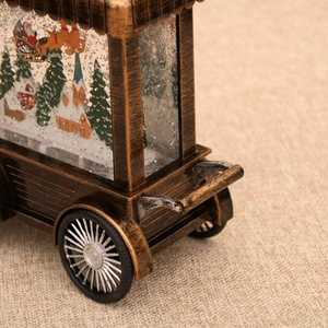 Close-up of vintage bronze Christmas cart snow globe showing Santa and snowy tree