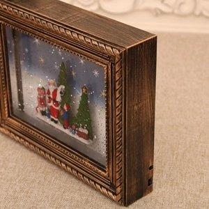 Detalle de caja musical navideña vintage con escena 3D de Papá Noel y marco de bronce