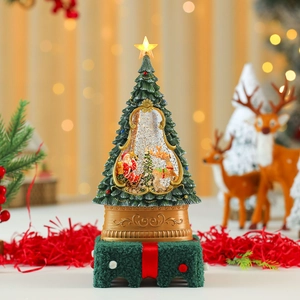 Detailed view of musical snow globe Christmas tree with glowing star and gift box base