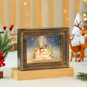 Detalle de marco navideño iluminado con muñeco de nieve, purpurina y borde dorado