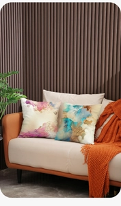 Detail of Nordic gold-stamped plush pillow with abstract fluid art on leather sofa