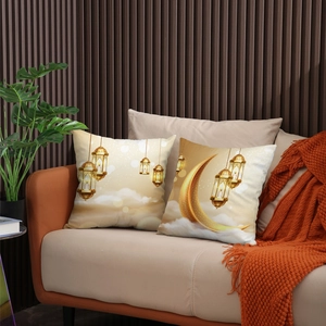 Decoratieve kussenset met maan en lantaarn voor Eid-decoratie op een oranje bank