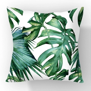 Minimalist square throw pillow with tropical palm and monstera leaves on white background