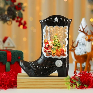 Détail macro de bottes boule à neige de Noël avec scène lumineuse du Père Noël