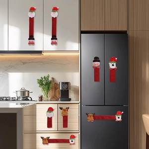 Detalle de fundas navideñas para pomos de cocina de reno en una nevera negra moderna