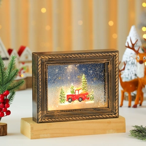 Detalle de marco navideño vintage con escena de nieve luminosa sobre base de madera
