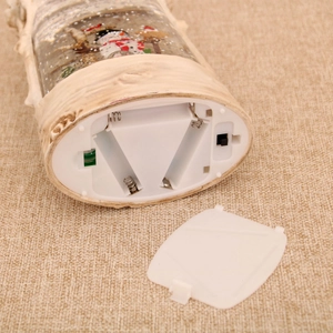 Detailed base view of Christmas snow globe showing the AAA battery compartment and switch