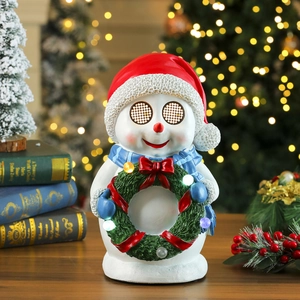 Close-up of a resin snowman music box with a glowing LED wreath and festive decor