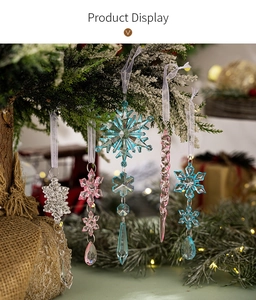 Clear acrylic snowflake ornaments on Christmas tree branch with warm festive lighting