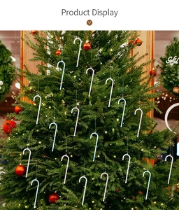 Sparkly acrylic candy cane ornaments with rhinestones hanging on a decorated Christmas tree