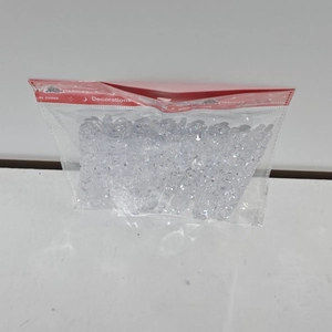 Macro detail of transparent acrylic icicle ornaments in bulk packaging for Christmas