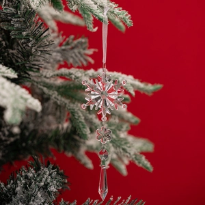 Detalle de colgante de copo de nieve acrílico con gota de hielo en rama de árbol de Navidad