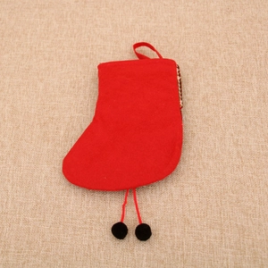 Detail of red Christmas stocking ornament with hanging rope and decorative black pom-poms