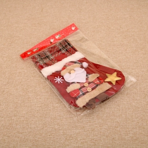 Detail of large plaid Christmas stocking with 3D Santa Claus and golden star ornament