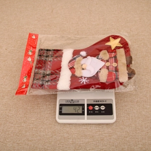 Detailed view of a red plaid Christmas stocking gift bag weighing 42g on a scale