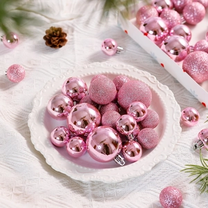 Pink Christmas ball ornaments in glossy and glitter finish displayed in a white bowl