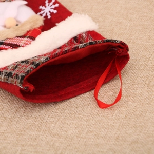 Close-up of red plaid Christmas stocking with Santa Claus applique and plush cuff decoration