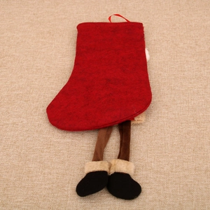 Detail of red Christmas stocking with stuffed decorative legs and white faux fur trim