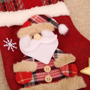 Detail of a red plaid Christmas stocking with a 3D Santa Claus and wooden button accents