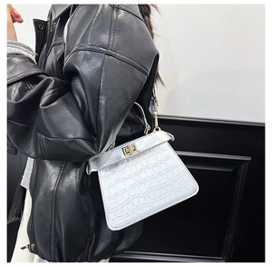 Dettaglio borsa kelly bianca con trama coccodrillo, patta argento e chiusura dorata
