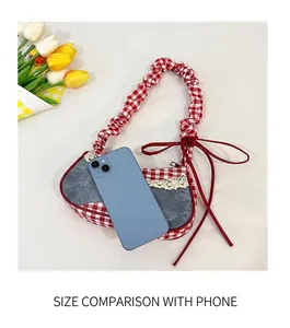 Detail of blue denim and red gingham patchwork bag with lace trim and bow accents