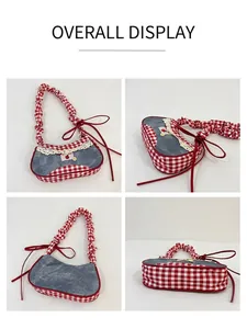 Detail view of denim underarm bag with red plaid trim, cherry patches and lace details