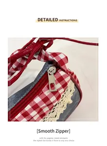 Detail of a denim shoulder bag with red checkered fabric, lace trim, and a metal zipper