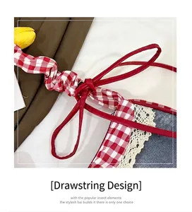 Close-up of drawstring shoulder strap with red plaid pattern and white lace edge detail