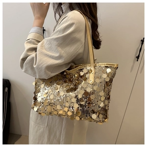 Dettaglio di una borsa tote grande con paillettes dorate che mostra la trama luccicante